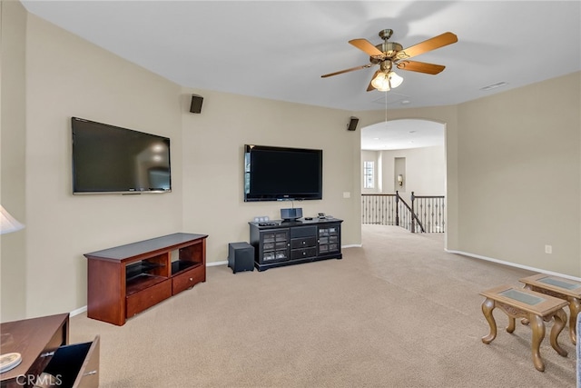 living area featuring visible vents, baseboards, a ceiling fan, and carpet flooring