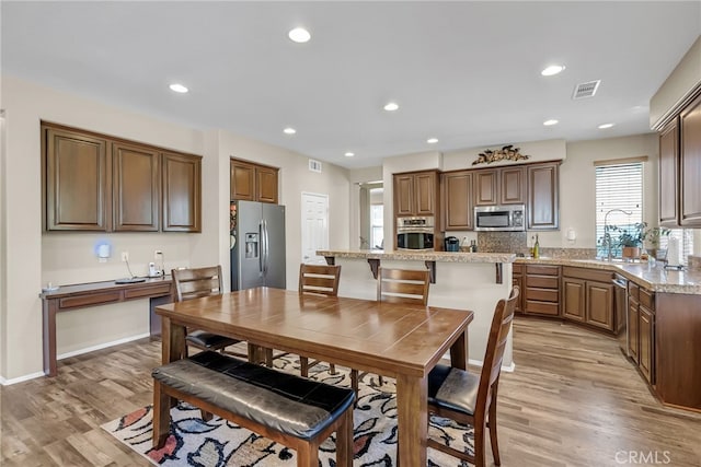 dining area with light wood-type flooring, visible vents, and recessed lighting