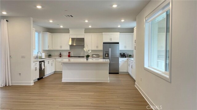 230 Sora, Irvine, CA 92618 - kitchen featuring light wood-style floors, appliances with stainless steel finishes, white cabinets, under cabinet range hood, and visible vents