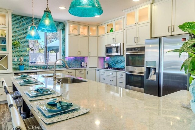 25279 Spur Branch Pl, Menifee, CA 92584 - kitchen with appliances with stainless steel finishes, a sink, light stone counters, and recessed lighting