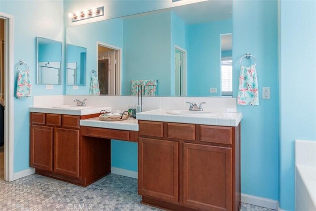 25279 Spur Branch Pl, Menifee, CA 92584 - bathroom with double vanity, a bathtub, and baseboards
