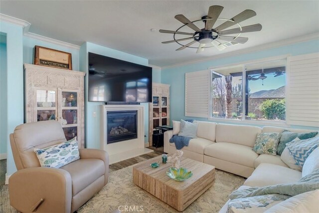 25279 Spur Branch Pl, Menifee, CA 92584 - living area with ornamental molding, a glass covered fireplace, ceiling fan, and wood finished floors
