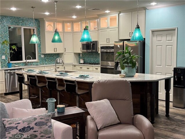 25279 Spur Branch Pl, Menifee, CA 92584 - kitchen with appliances with stainless steel finishes, decorative backsplash, a kitchen breakfast bar, dark wood-style floors, and recessed lighting