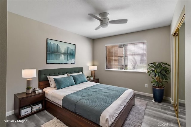 bedroom featuring a closet, baseboards, a ceiling fan, and wood finished floors