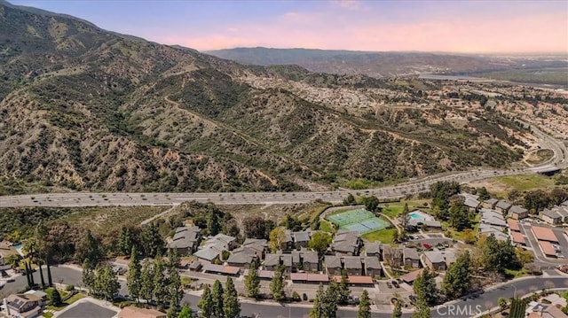 aerial view at dusk featuring a mountain view