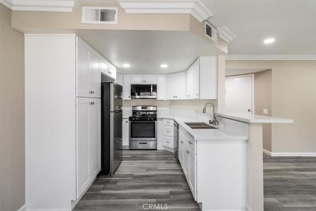 kitchen featuring appliances with stainless steel finishes, wood finished floors, a sink, and visible vents