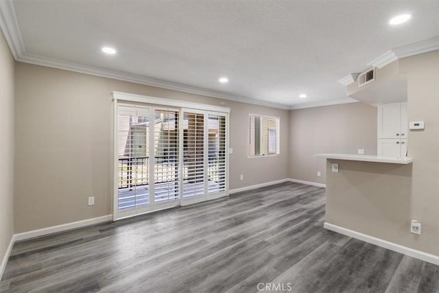 spare room with dark wood-style floors, baseboards, and ornamental molding