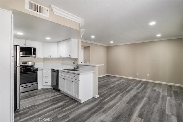kitchen featuring recessed lighting, a peninsula, visible vents, appliances with stainless steel finishes, and a sink