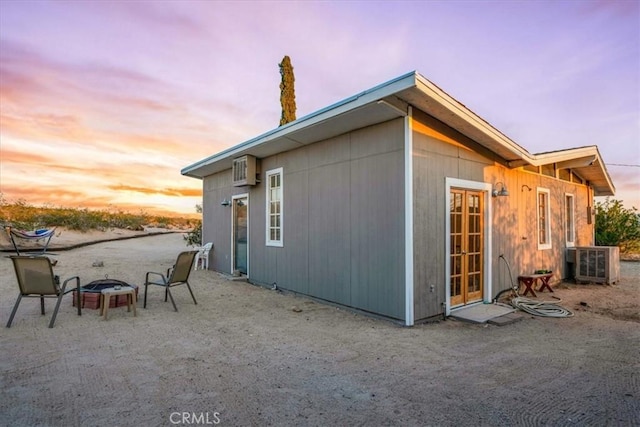 63854 Orion Rd, Joshua Tree, CA 92252 - property exterior at dusk featuring a fire pit, central air condition unit, and a patio area