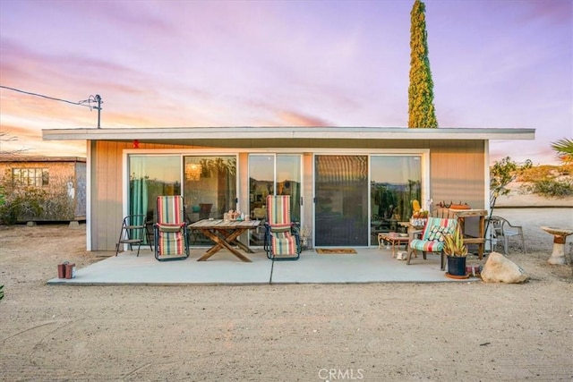 63854 Orion Rd, Joshua Tree, CA 92252 - back of house at dusk featuring a patio