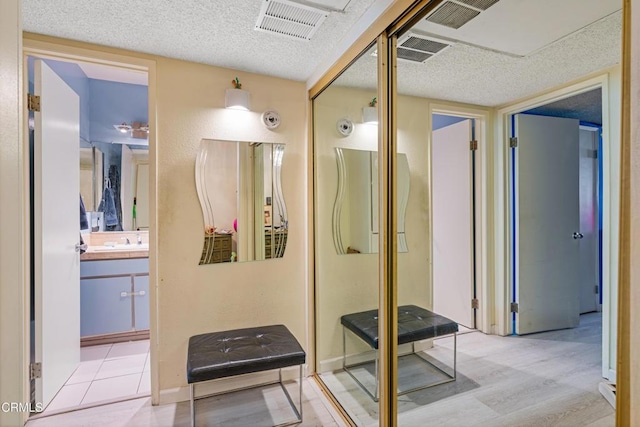 bathroom with vanity, a textured ceiling, and visible vents