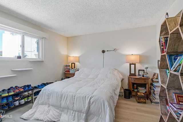 bedroom featuring wood finished floors and a textured ceiling