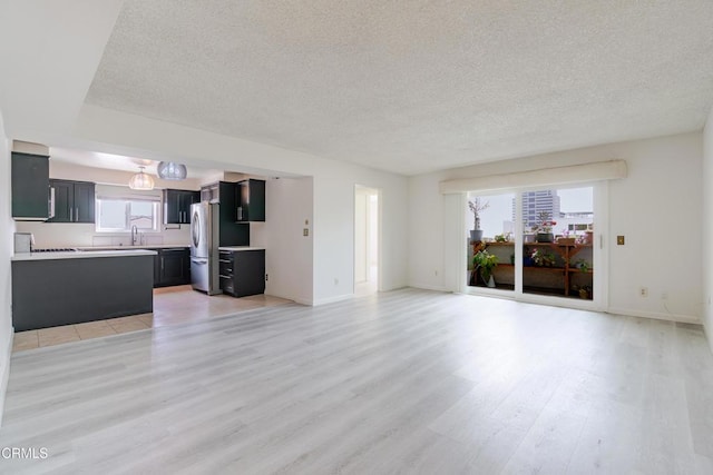 500 Jackson Pl Unit 313, Glendale, CA 91206 - unfurnished living room with light wood-type flooring, a textured ceiling, a sink, and baseboards