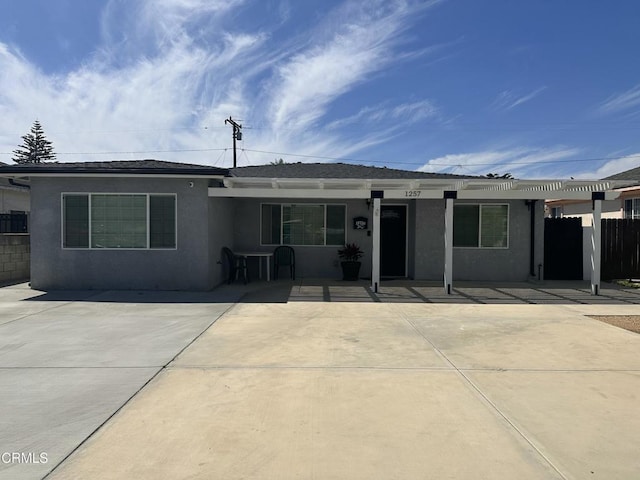 view of front of house featuring stucco siding and fence