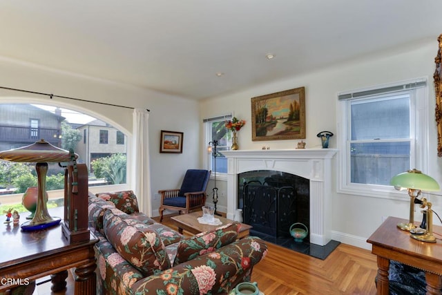 living room featuring a fireplace with raised hearth and baseboards