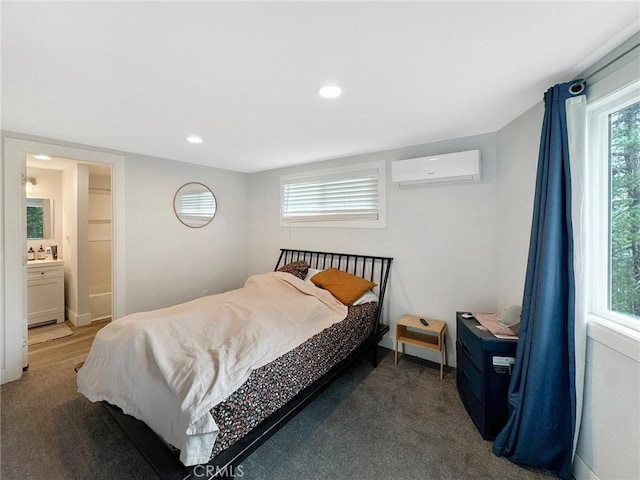 bedroom featuring recessed lighting, ensuite bathroom, and an AC wall unit