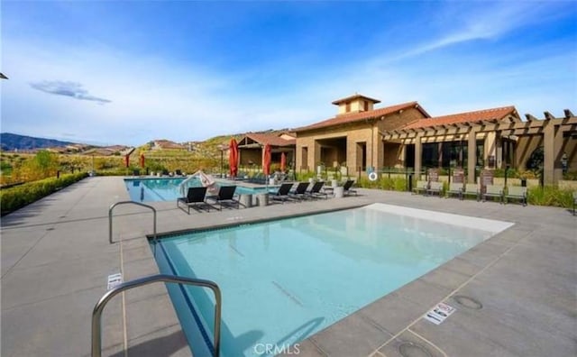 pool with a pergola and a patio area