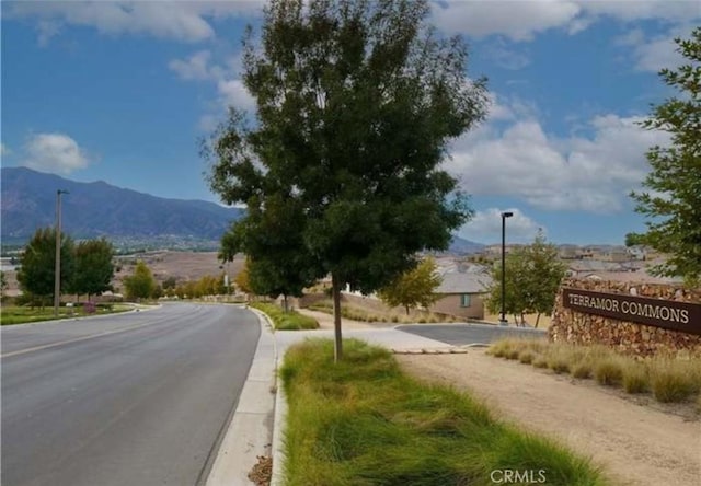 view of street featuring curbs, street lighting, and a mountain view
