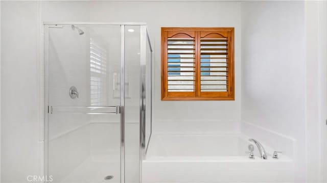 full bath featuring a garden tub and a stall shower