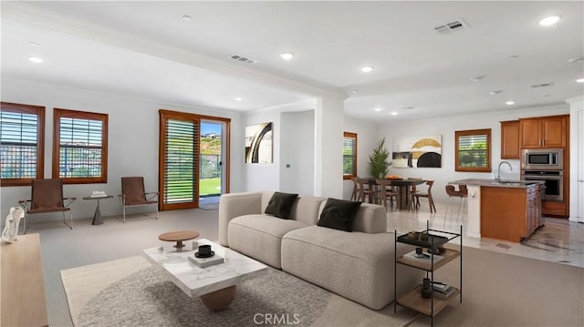 living area featuring crown molding, visible vents, and a wealth of natural light