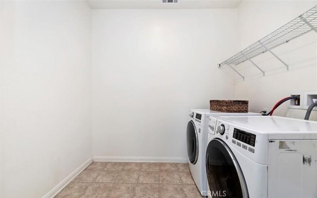 laundry area featuring baseboards, visible vents, washer and dryer, and laundry area