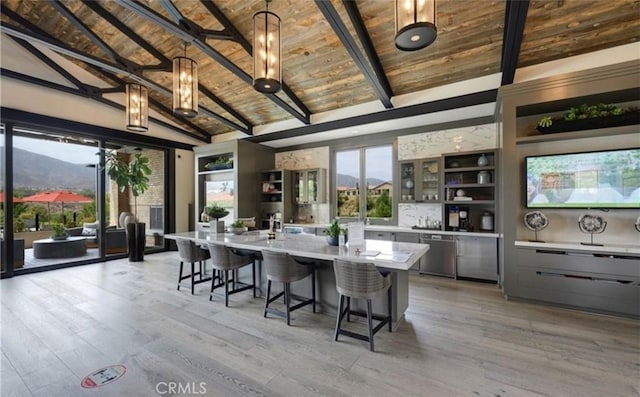 kitchen with a healthy amount of sunlight, lofted ceiling with beams, light countertops, and wooden ceiling