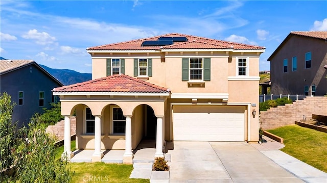 mediterranean / spanish house featuring covered porch, stucco siding, concrete driveway, an attached garage, and fence