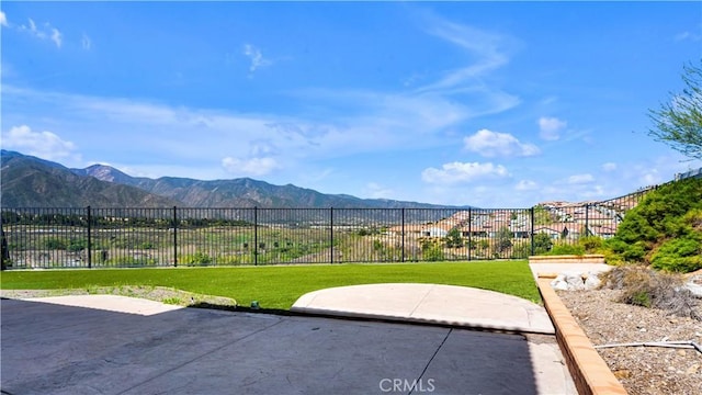 view of patio with a mountain view and fence