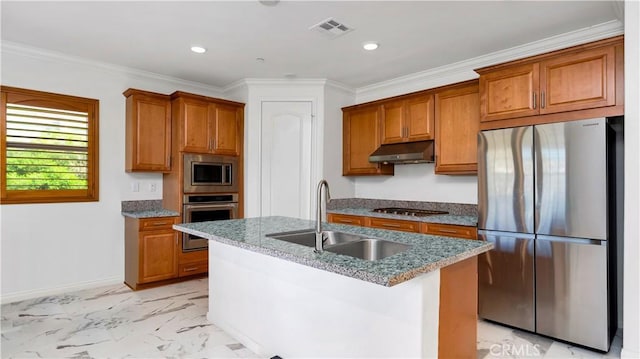 kitchen with under cabinet range hood, brown cabinets, appliances with stainless steel finishes, and a sink