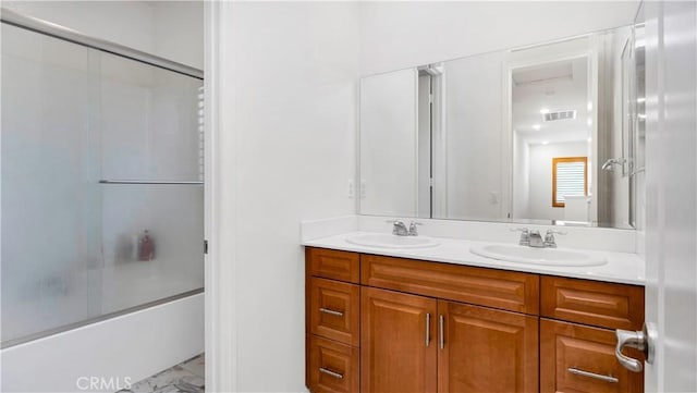 full bath with double vanity, visible vents, marble finish floor, and a sink