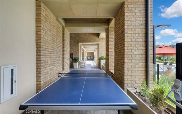 recreation room featuring brick wall
