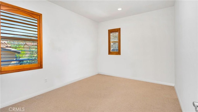 unfurnished room featuring baseboards, recessed lighting, and light colored carpet