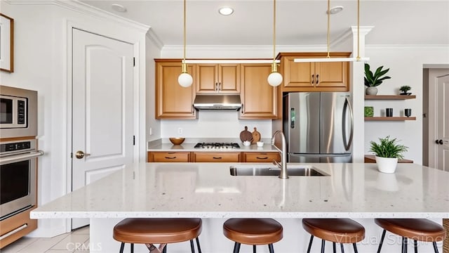 24845 Elison Ct, Corona, CA 92883 - kitchen featuring appliances with stainless steel finishes, a sink, under cabinet range hood, a breakfast bar area, and ornamental molding