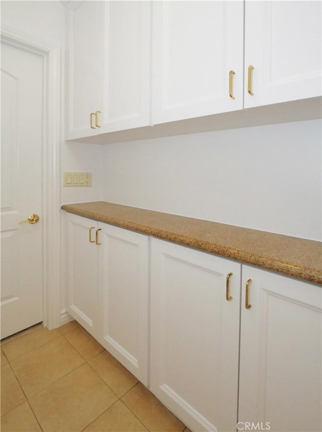 interior space with white cabinets and light tile patterned floors