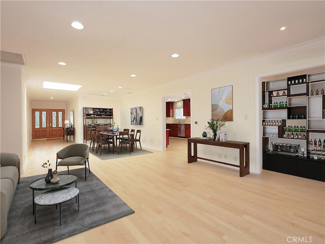 living area featuring crown molding, light wood finished floors, visible vents, and recessed lighting