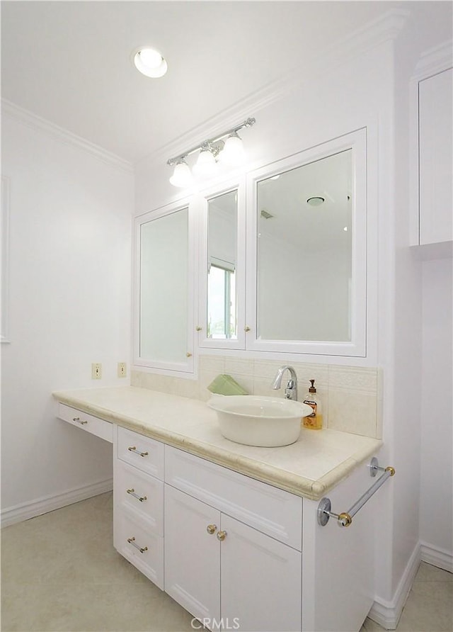 bathroom featuring crown molding, vanity, and baseboards