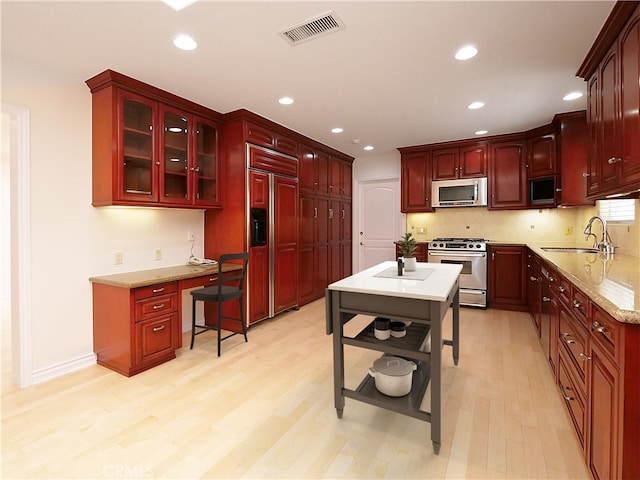 kitchen with visible vents, a sink, dark brown cabinets, and stainless steel appliances