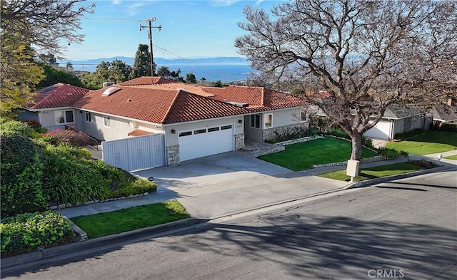 mediterranean / spanish house featuring fence, a front lawn, a tile roof, an attached garage, and driveway