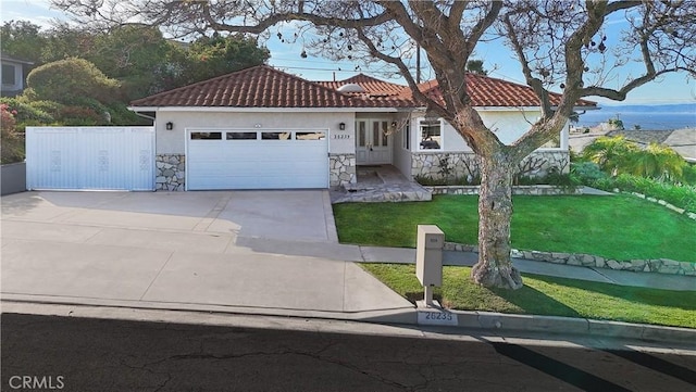 26235 Birchfield Ave, Rancho Palos Verdes, CA 90275 - mediterranean / spanish home with an attached garage, concrete driveway, a tile roof, and stone siding