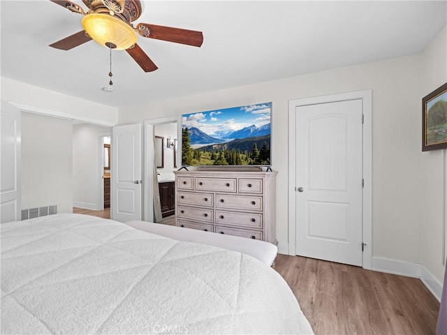 bedroom featuring wood finished floors, baseboards, and visible vents