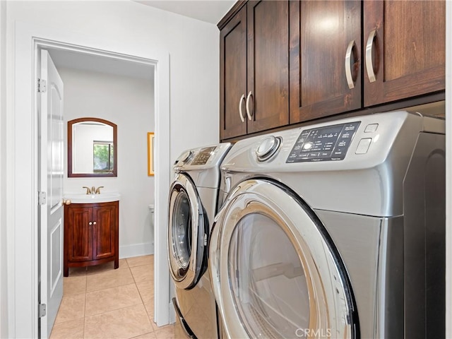 laundry area with cabinet space, a sink, separate washer and dryer, and light tile patterned flooring