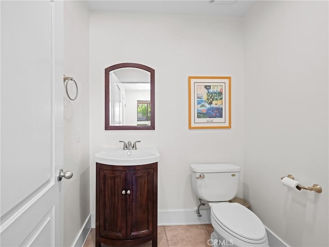 half bath featuring tile patterned flooring, vanity, baseboards, and toilet
