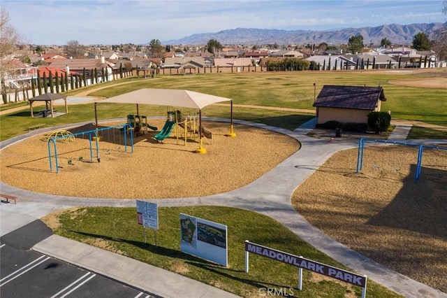 surrounding community featuring a mountain view, a lawn, a residential view, and playground community