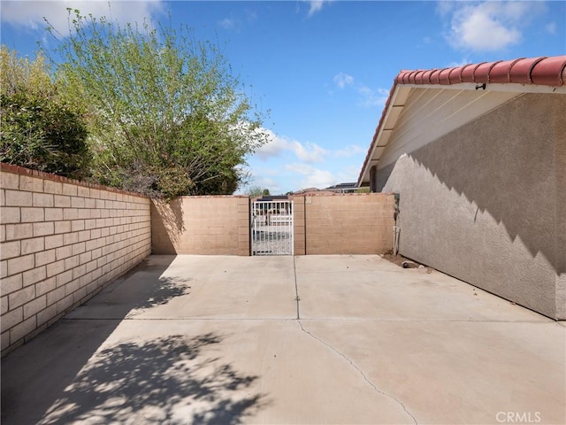 view of patio featuring fence and a gate