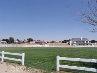 view of yard with fence and a rural view