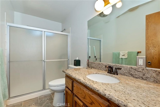 full bath featuring toilet, vanity, a stall shower, and tile patterned flooring