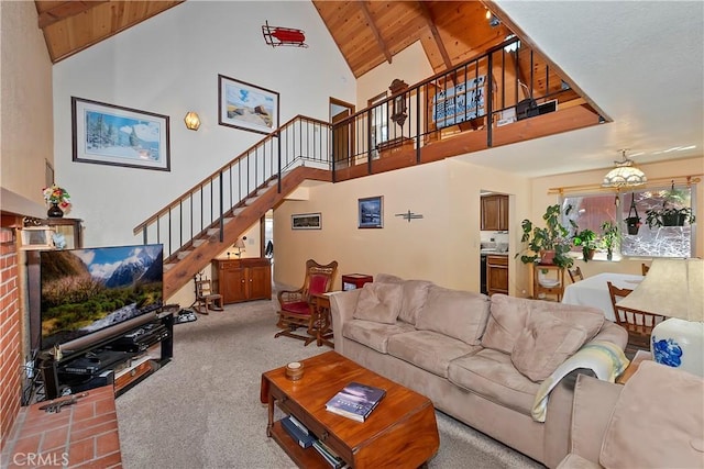 carpeted living room featuring beamed ceiling, high vaulted ceiling, wooden ceiling, and stairs