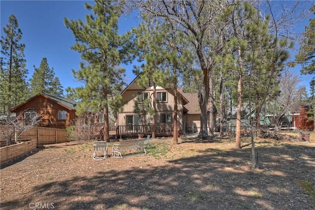 rear view of property with fence and a deck