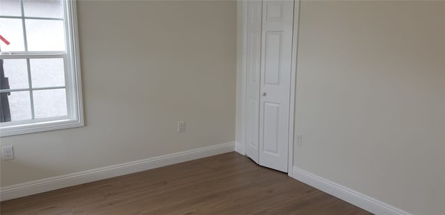 interior space featuring baseboards and dark wood-type flooring
