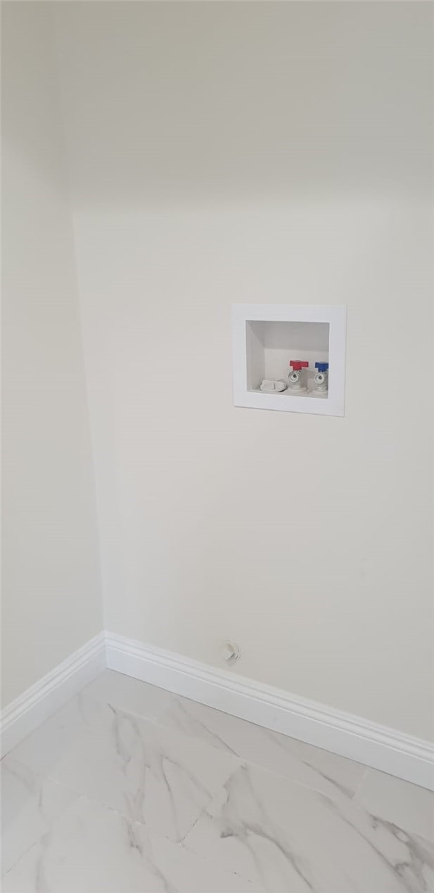 clothes washing area with washer hookup, marble finish floor, laundry area, and baseboards